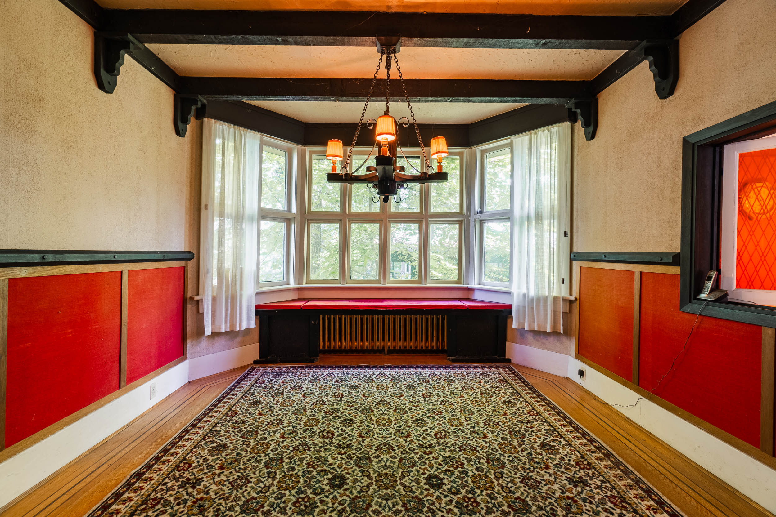 Formal dining room with bay window, original beams and chandelier