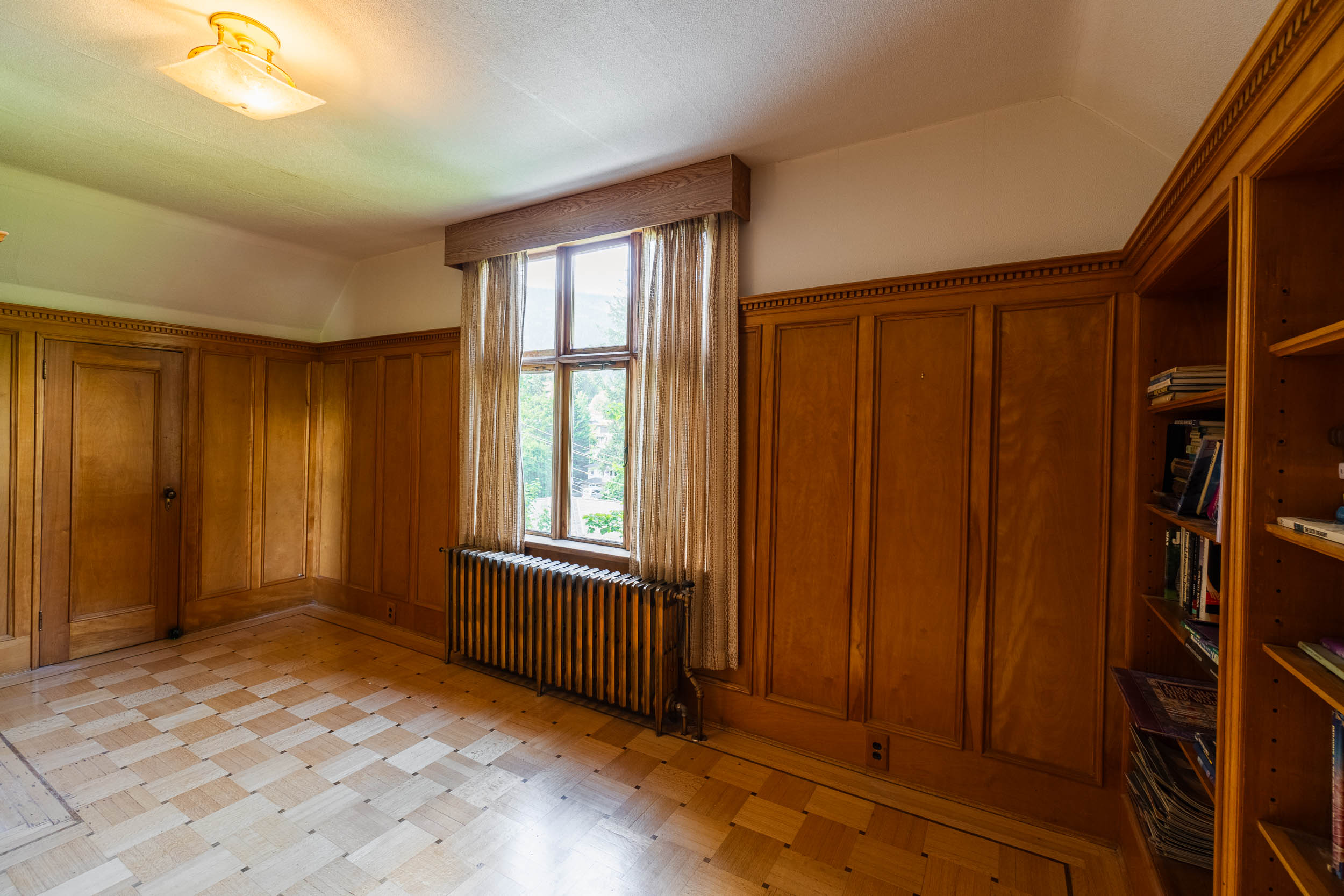 Oak panelling, original radiator, built-in shelving and patterned hardwood floor