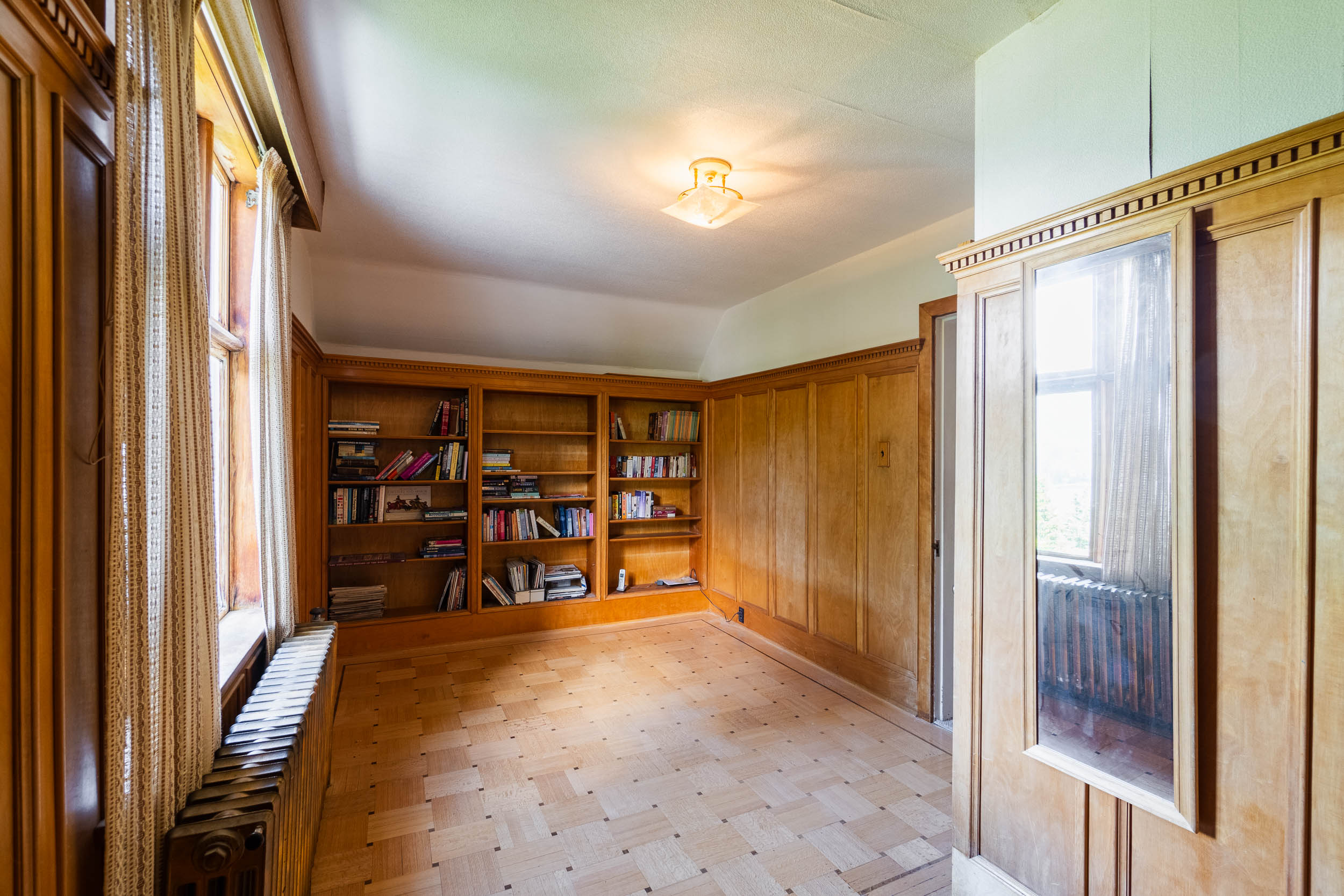 Bedroom with wood panelling and built-in bookcases