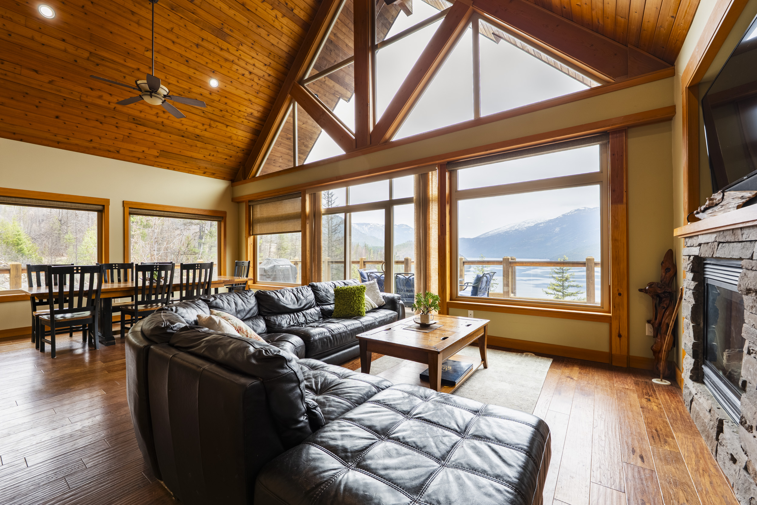 Timber-frame great room with vaulted ceiling, fireplace and lake views