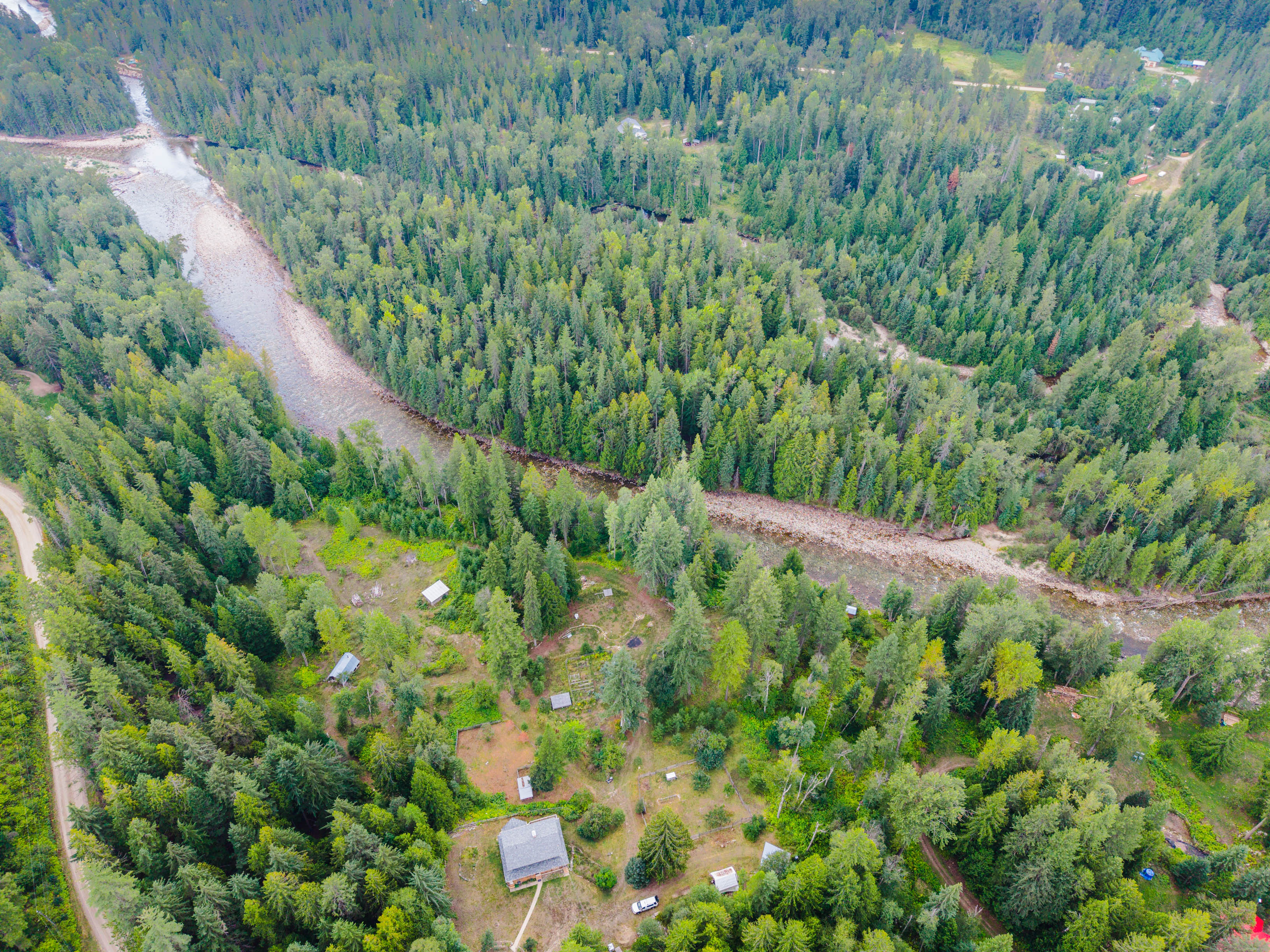 Aerial view of the acreage at 3360 Little Slocan South Road with the Little Slocan River winding through the surrounding forest.
