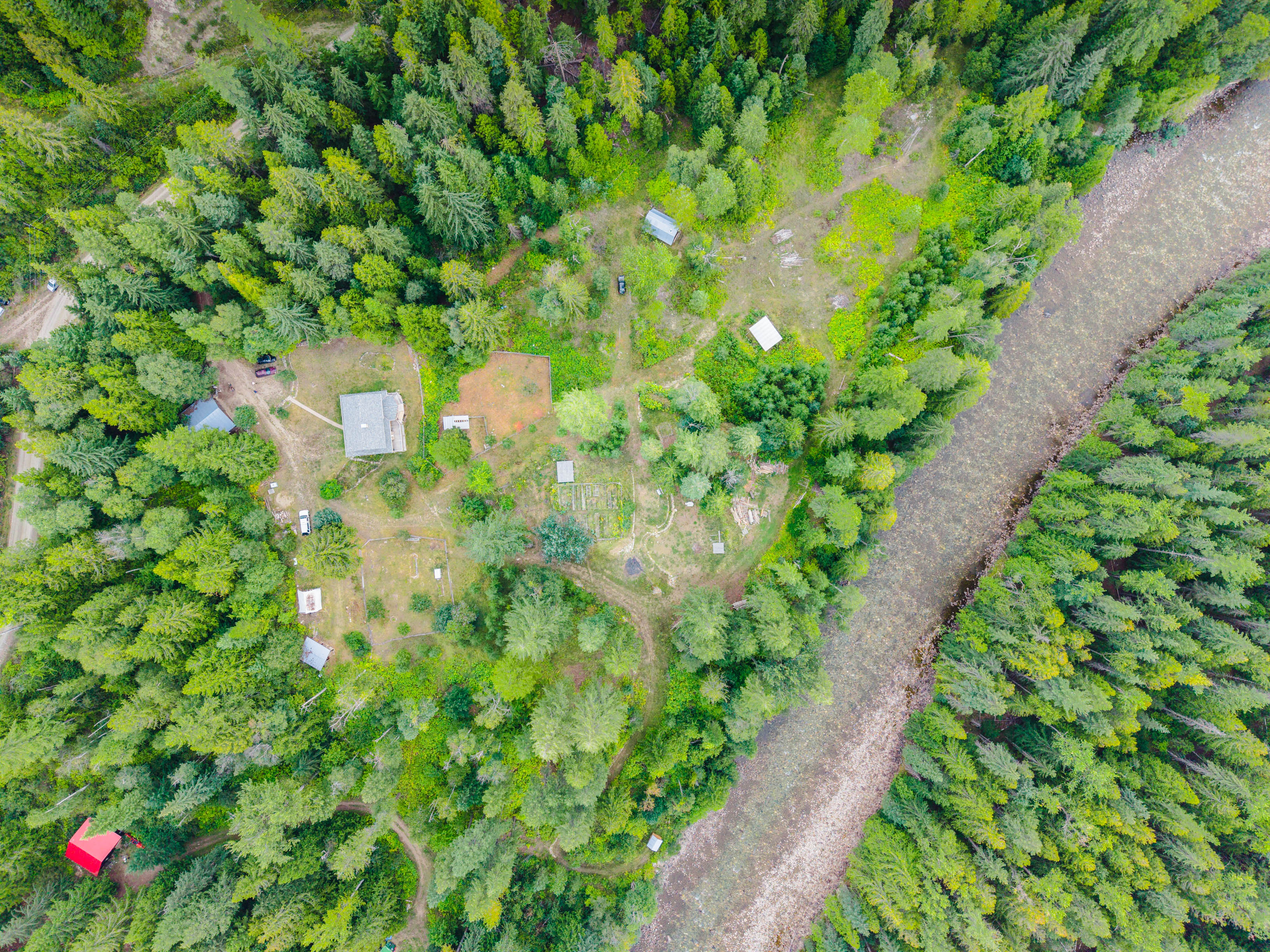 Aerial view of 3360 Little Slocan South Road in Passmore, BC, showing the acreage beside the Little Slocan River and surrounded by forest.