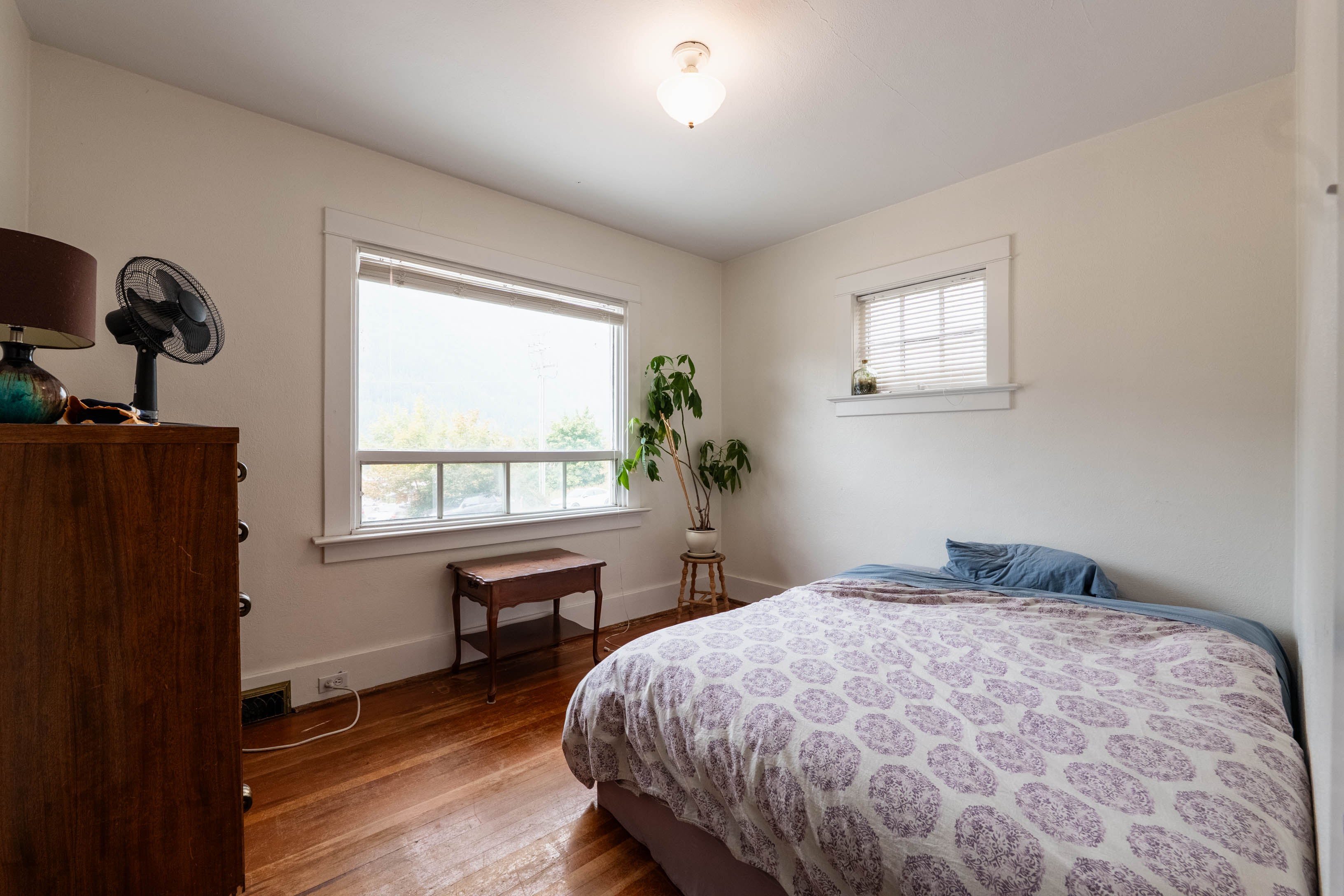 Bedroom with hardwood flooring and windows