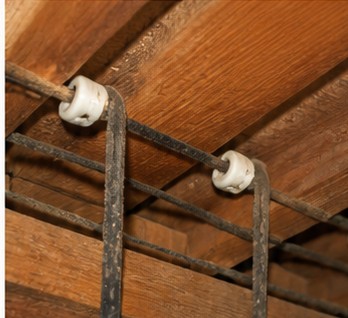 Knob-and-tube electrical wiring supported by porcelain knobs in older timber framing