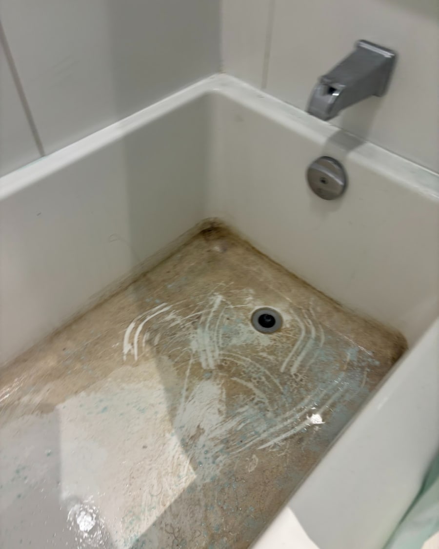 A shower with soap scum and buildup before cleaning
