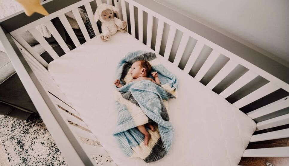 newborn sleeping in a crib