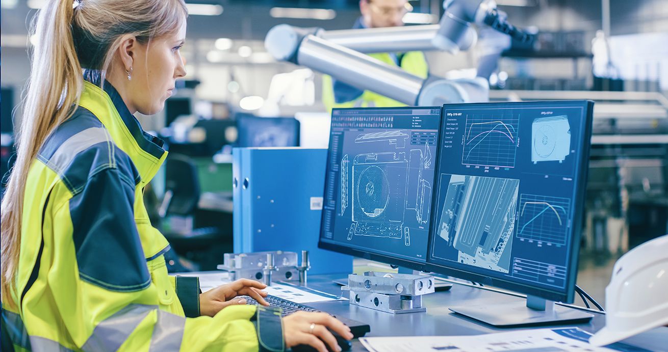 A woman in a high-vis jacket looking at mini-split blueprints on the computer