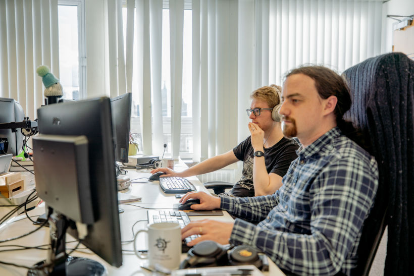 Kythera AI team members at work in the office, using computers.