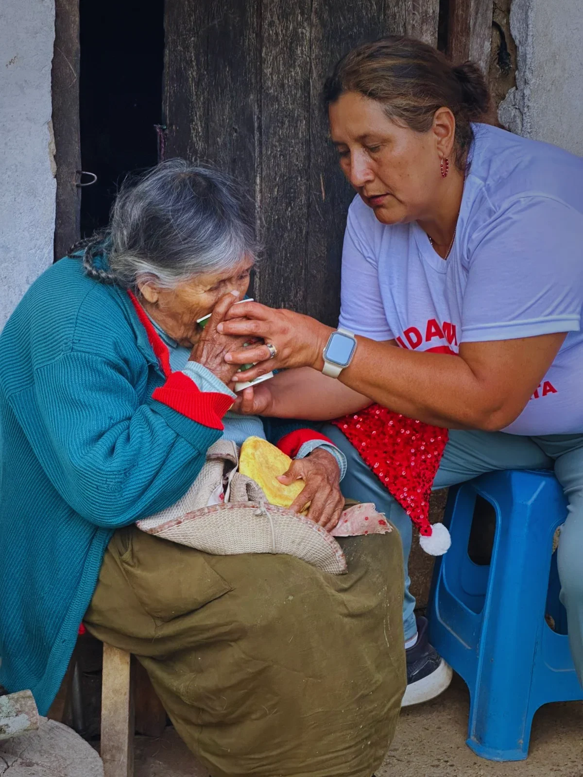 A volunteer sharing a tender moment with an Andean elder
