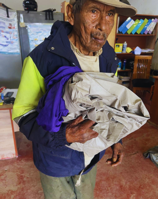 An Andean elder holding supplies