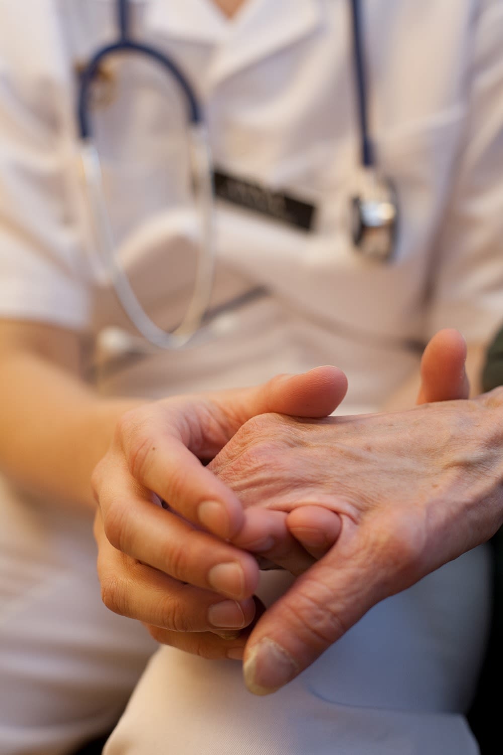 Läkare håller sin patients hand.