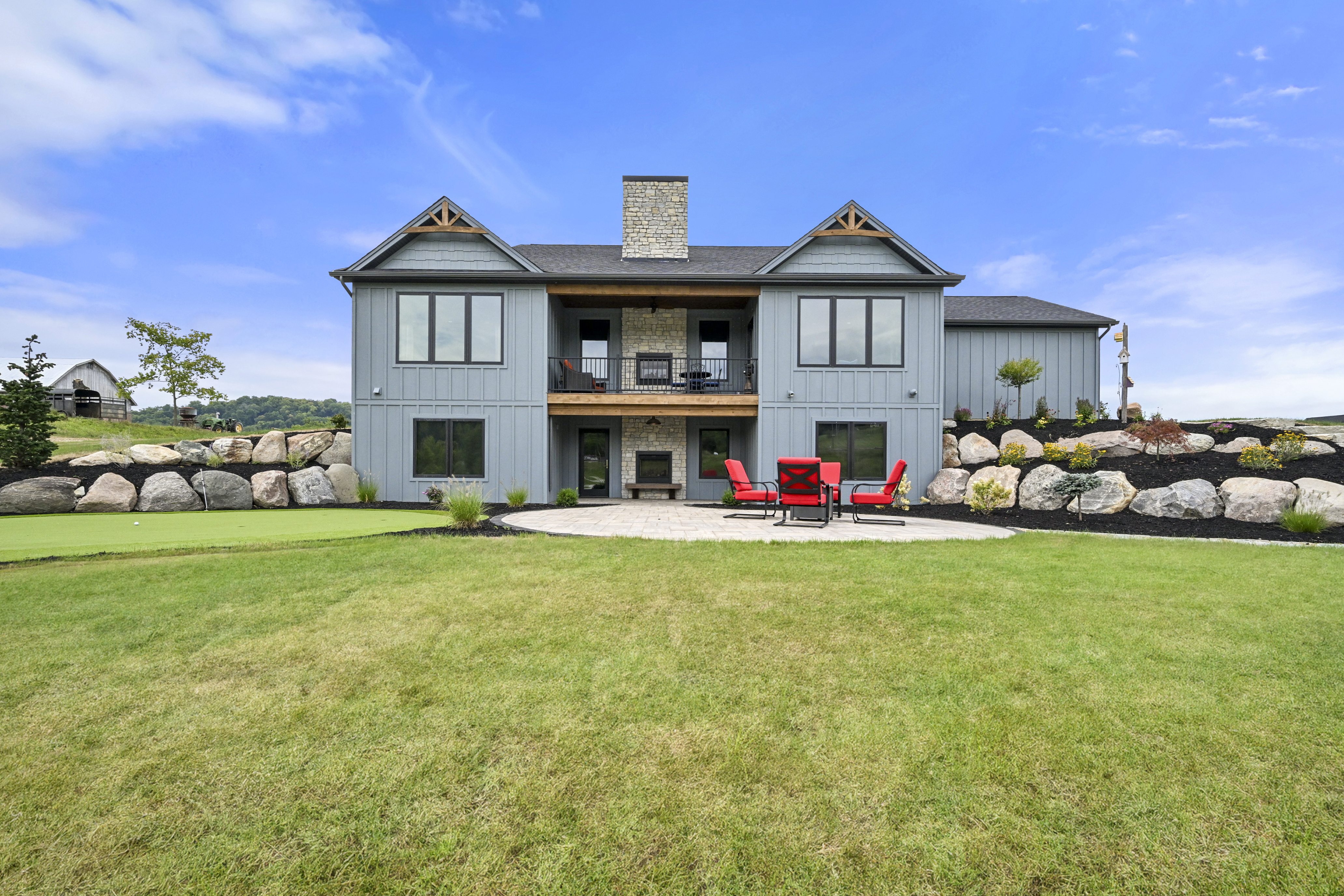 Covered rear porch with outdoor furniture in custom Indiana home