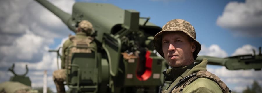 Артилерист у панамі біля ствола гаубиці на позиції