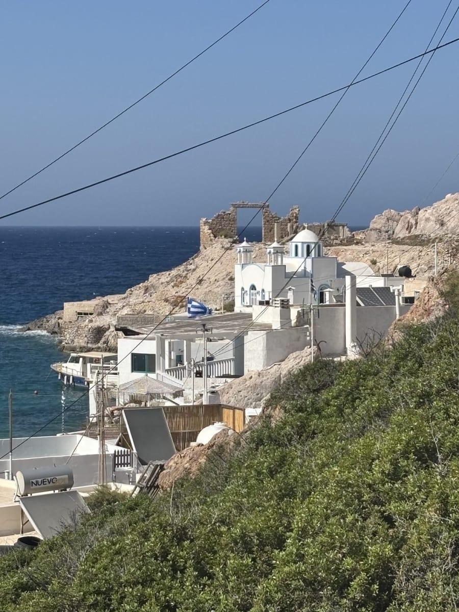 Klima from the beach — the syrmata boat garages line the waterline exactly as they have for over a century.