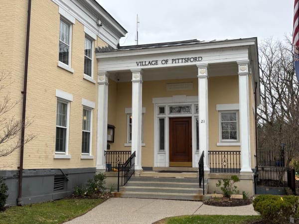 Village of Pittsford municipal building with classical columns and red door entrance.