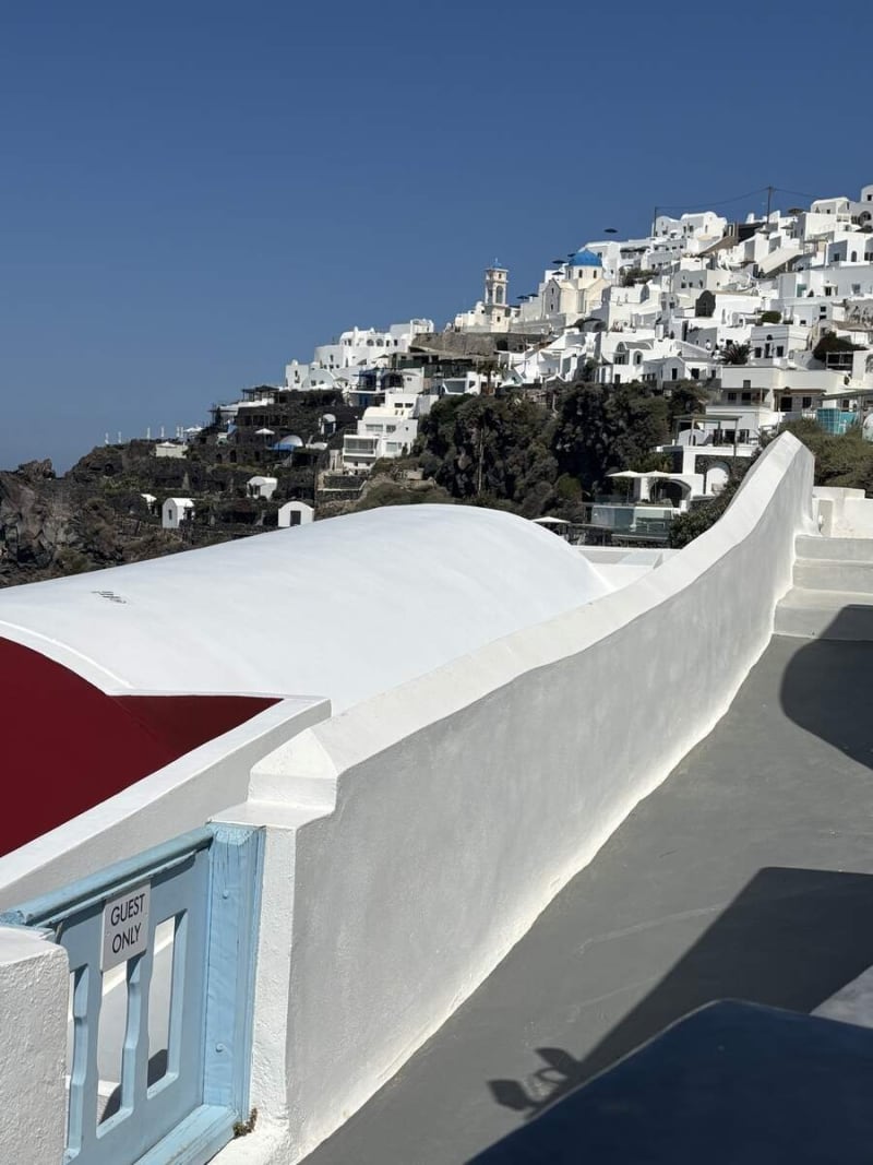 The Guest Only gate at the edge of a caldera-view terrace in Imerovigli