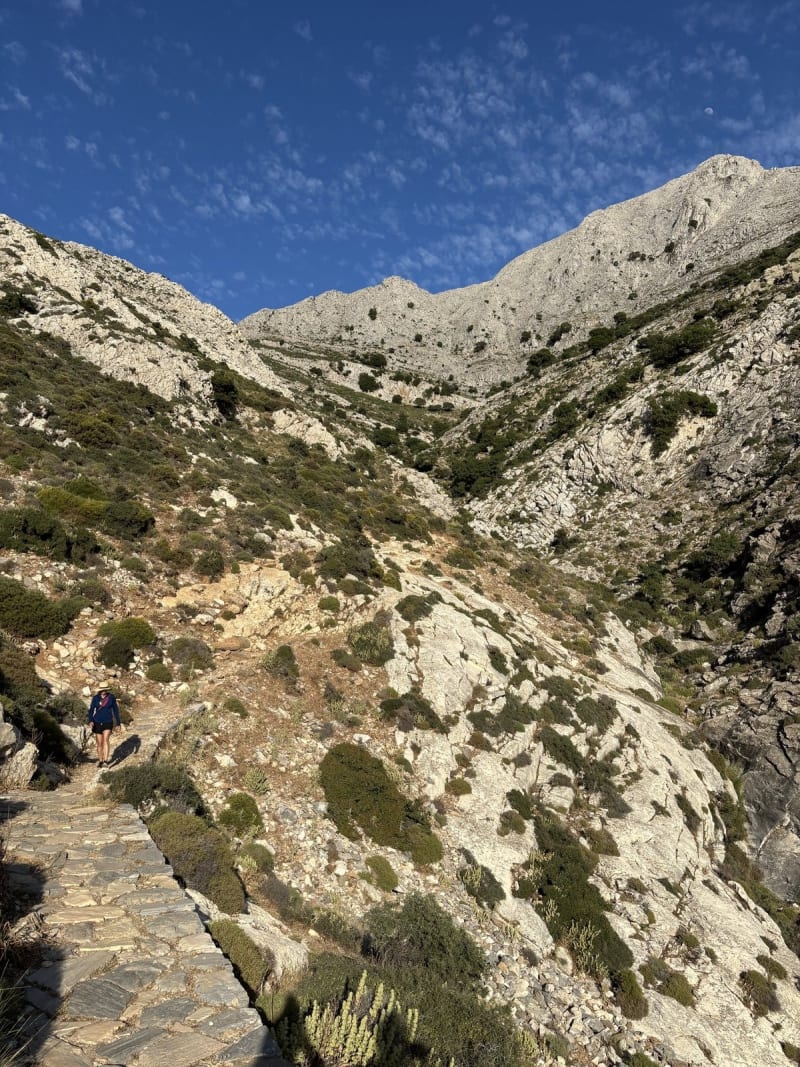 The path down from Zas. Ancient paving stones, afternoon light, and the moon already up. The mountain earns its mythology.
