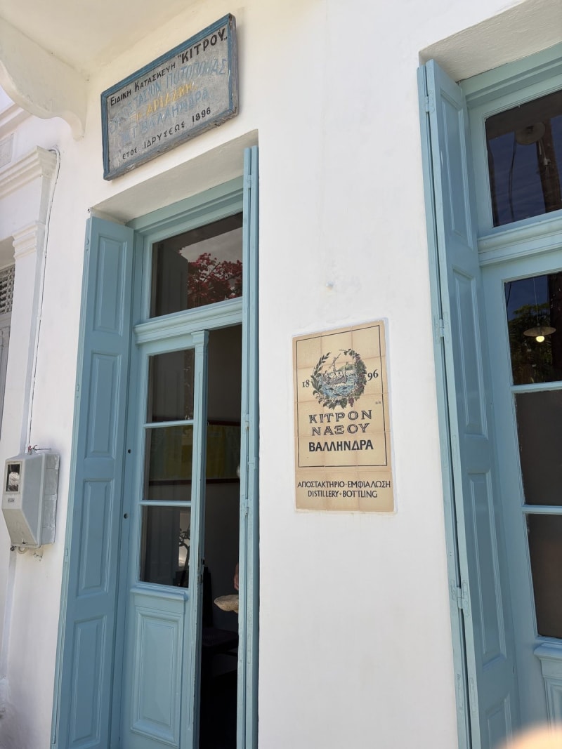 The Vallindras distillery entrance in Halki — blue shutters, 1896 founding plaque.