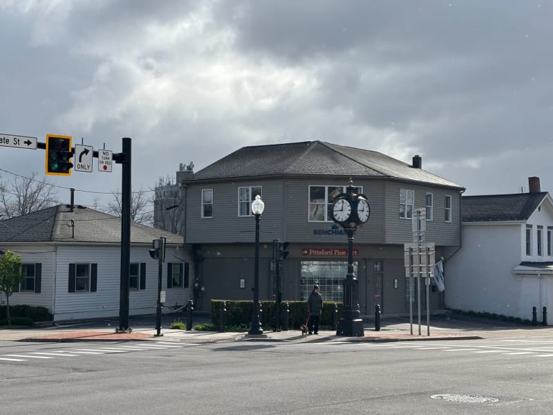 # Alt Text
Historic downtown building with dual clock tower and street-level storefront on a cloudy day.
