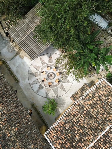 Sân chung homestay nhìn từ trên cao với hoa văn tròn giữa sân