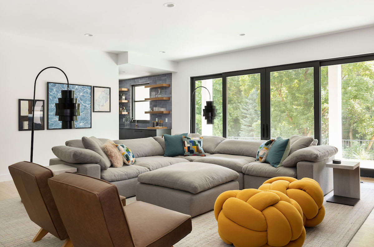 Modern Manor sitting room with a curved sofa and a stone fireplace