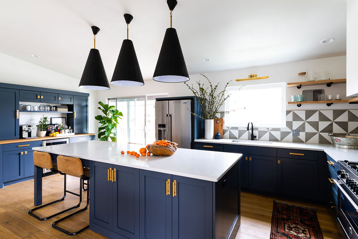 Updated kitchen remodel with deep blue cabinetry and stainless steel appliances.