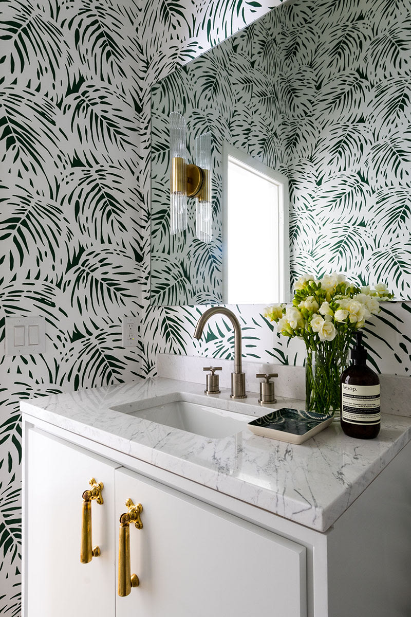 Classy and modern bathroom redesign with plant leaf pattered wallpaper.