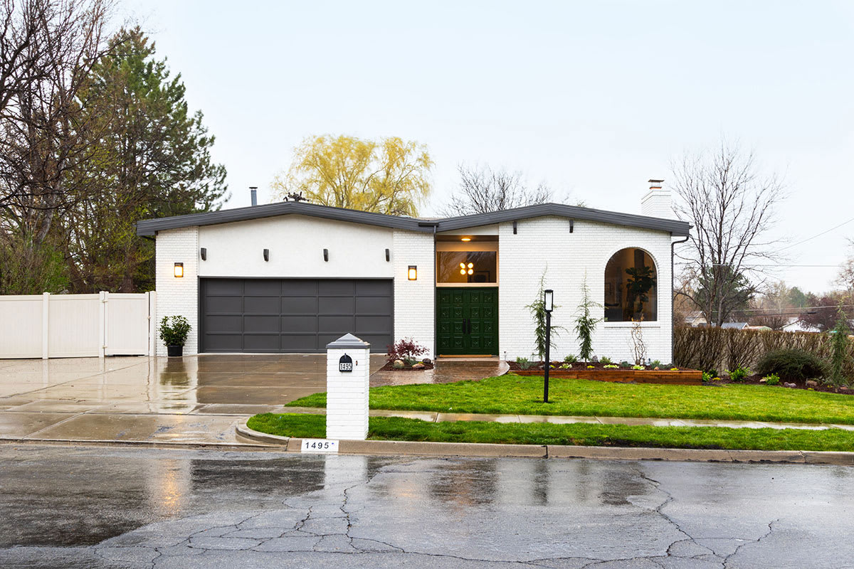 Modern painted brick home remodel with large windows.