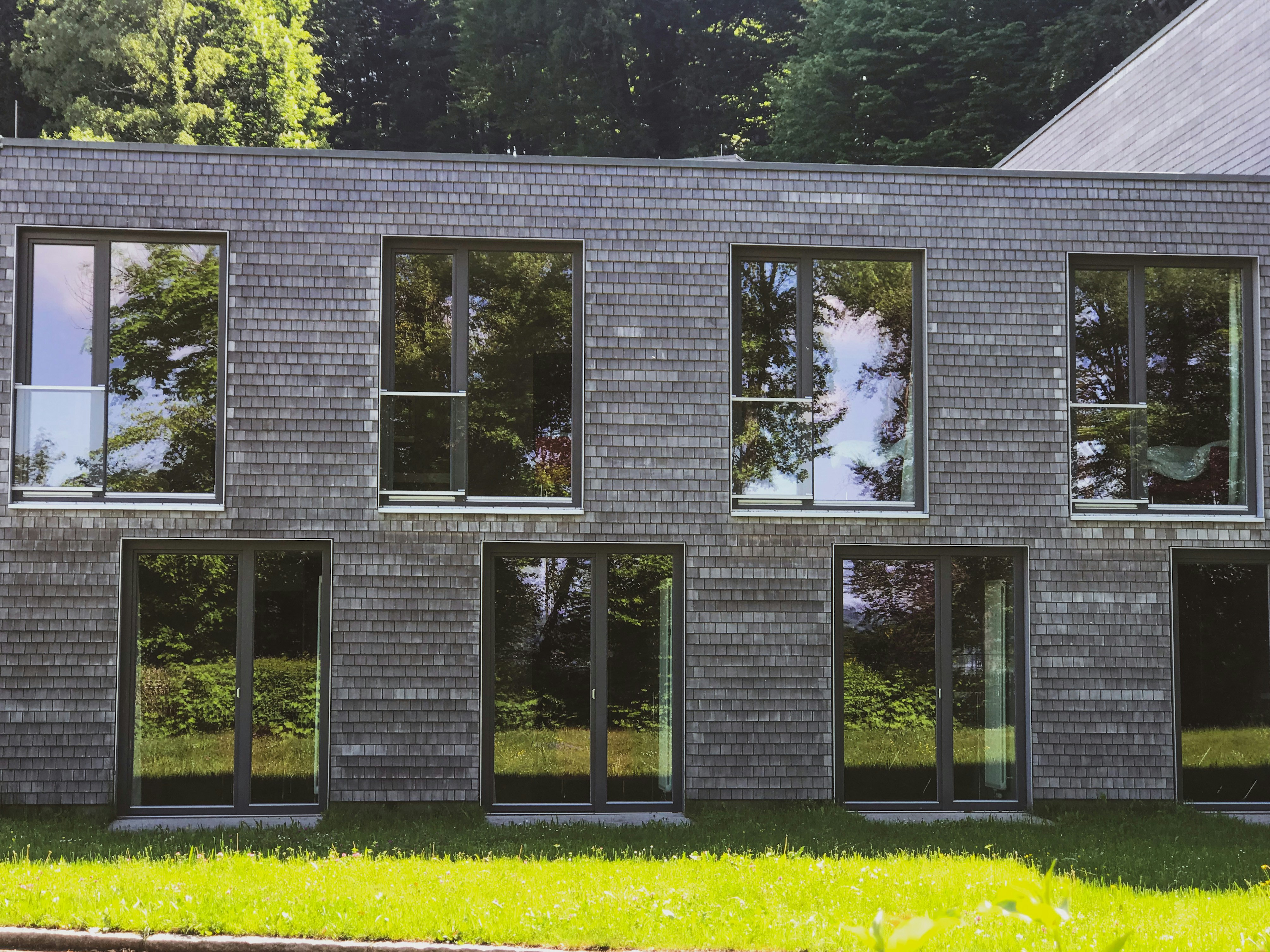 Villa contemporaine avec baies vitrées aluminium et vue panoramique sur lac, architecture moderne