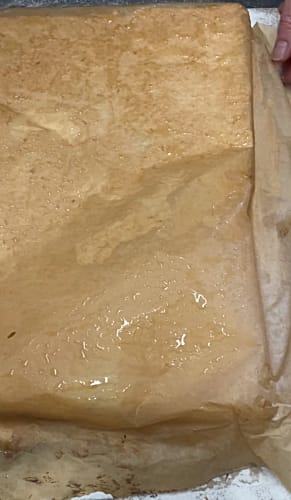 Baking parchment lining paper covering the cooked roulade on a work surface.