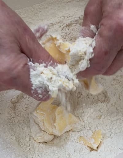 Butter being rubbed into the flour mixture by hand