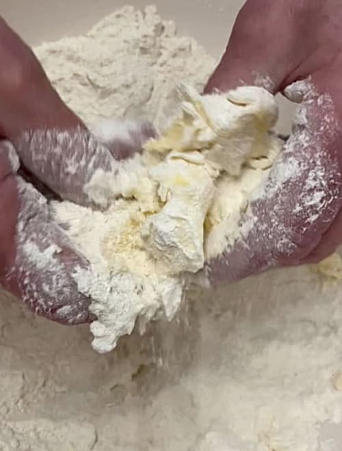 Butter being rubbed into the flour mixture.