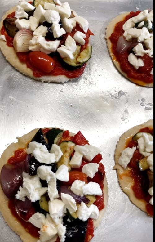 Mozzarella pieces added to the top of the pizzas.