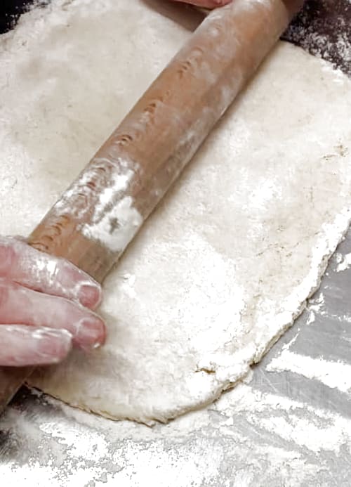 Pastry being rolled out onto a well floured board.