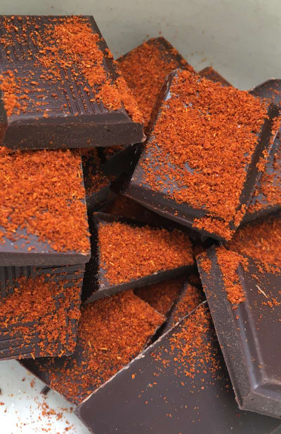 Dark chocolate chunks with chilli powder poured on top in a bowl