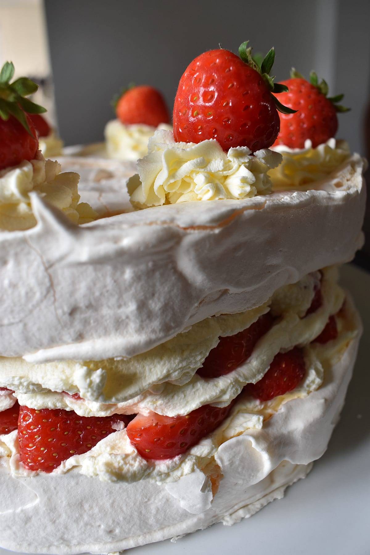 Close up from the side of whole Strawberry Meringue Gateau