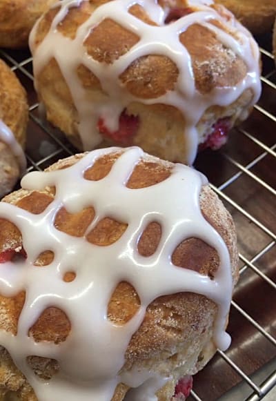 Scones on a wire rack with melted white chocolate drizzled on the top