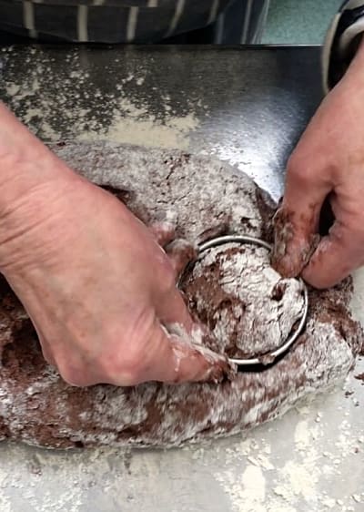 Sc one being cut out of the dough with a round metal cutter