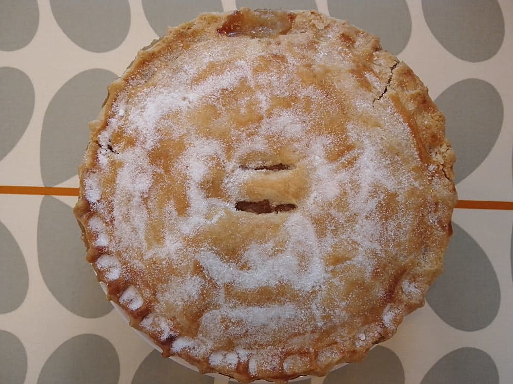 Whole apple pie on a patterned tablecloth