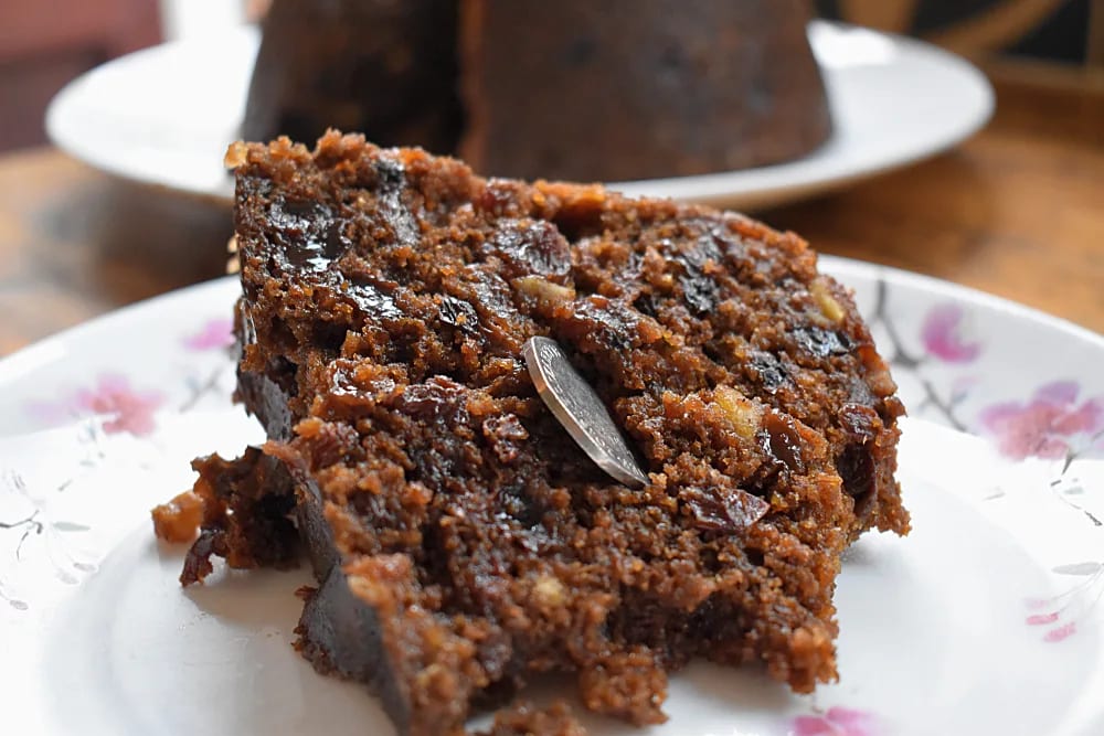 Halloween Pudding slice on a plate with a 50p coin stuck in the side.
