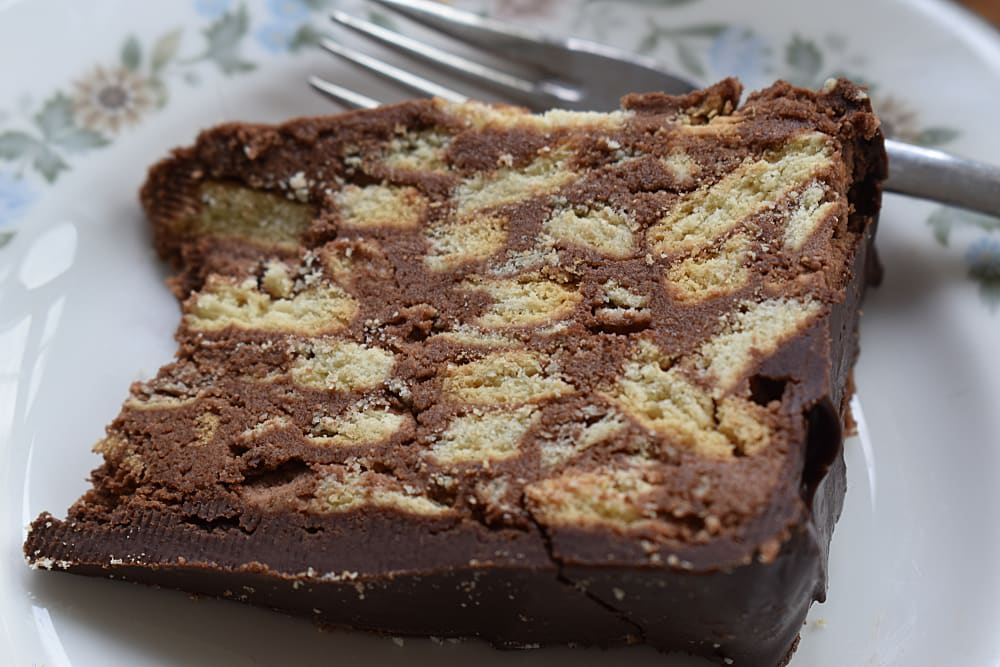 Slice of Queen Elizabeth's Chocolate Biscuit Cake on a plate with a fork
