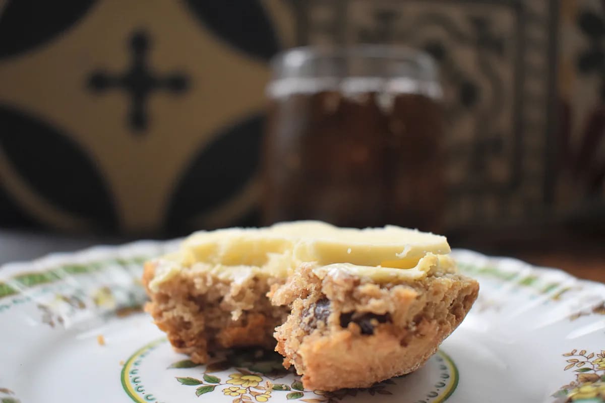 Beremeal date scone served with cheese with a bite taken out and a glass of beer in the background.
