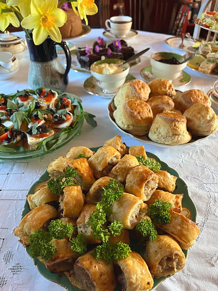 Afternoon Tea spread served on plates and cake stand on a pretty tablecloth