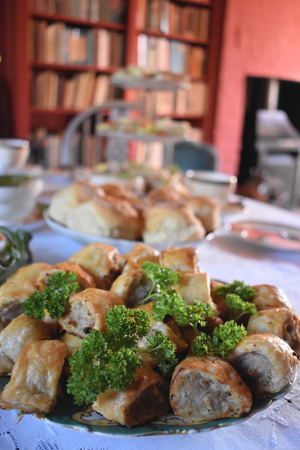 Mini sausage rolls on a plate with a parsley garnish
