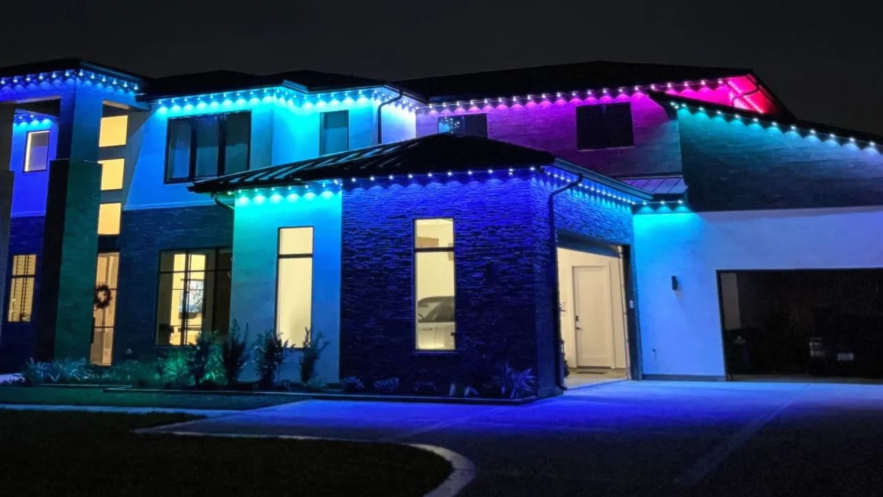 Home with permanent outdoor LED roofline lighting installed by LivelyLightingCo, lit in warm white at dusk