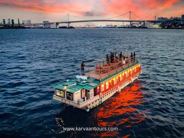 Dinner cruise boat sailing in Tokyo Bay at sunset with Rainbow Bridge in Odaiba Tokyo
