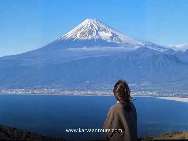 alt txt: Woman overlooking a bay with Mt Fuji in the background