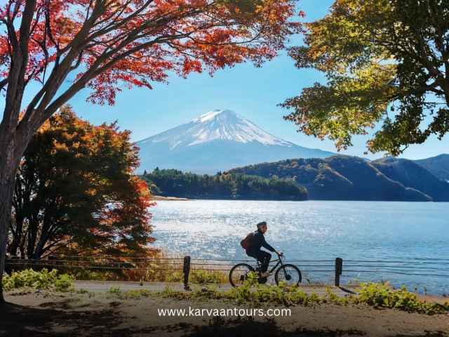 Person cycling on a path along Lake Kawaguchi in autumn