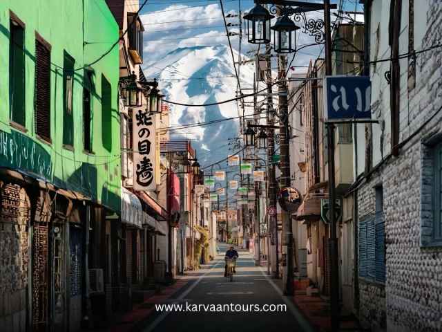 Narrow Japanese street with shops and Mount Fuji in background