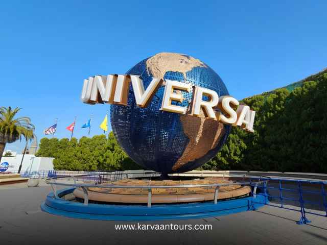 The famous rotating Universal Studios globe monument at the park entrance under a clear blue sky in Osaka, Japan.
